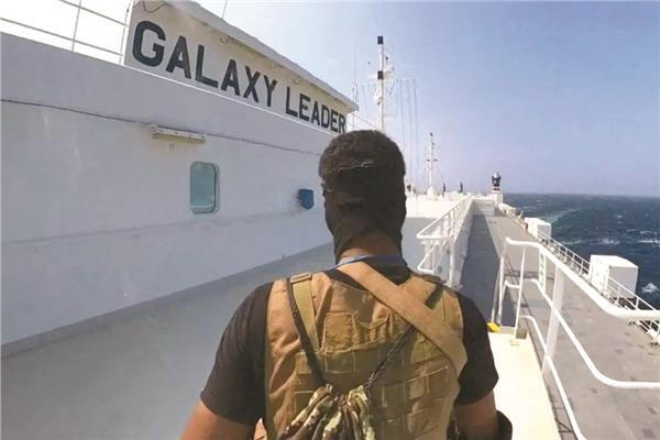 حوثي يقف على سفينة شحن مختطفة في البحر الأحمر
