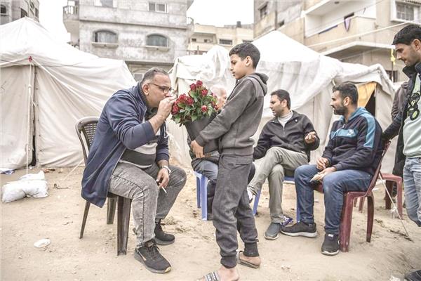 الطفل «قاسم» يوزع الورود على مواطنين غزة