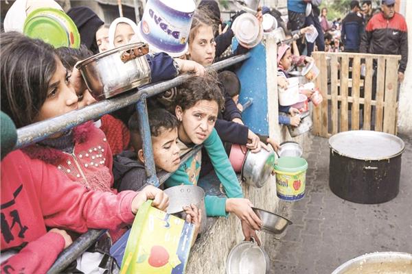 أطفال فلسطينيون جوعي ينتظرون الحصول على طعام