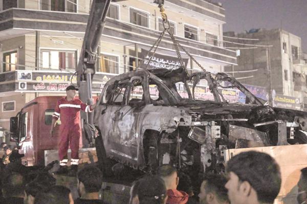 رفع سيارة محطمة على شاحنة بعد استهدافها بطائرة مسيّرة فى بغداد