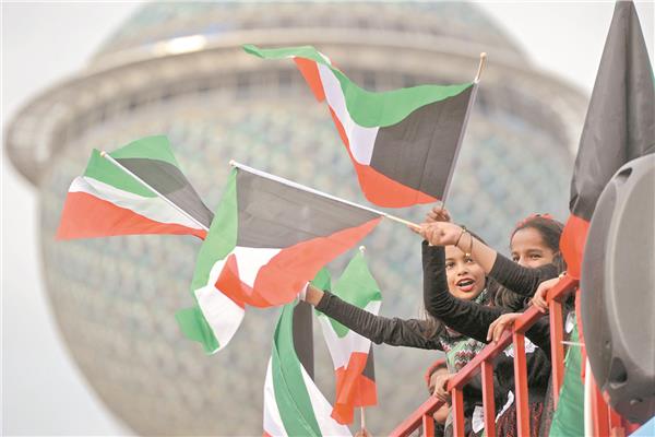 أطفال يحملون علم دولة الكويت في عيد الإستقلال