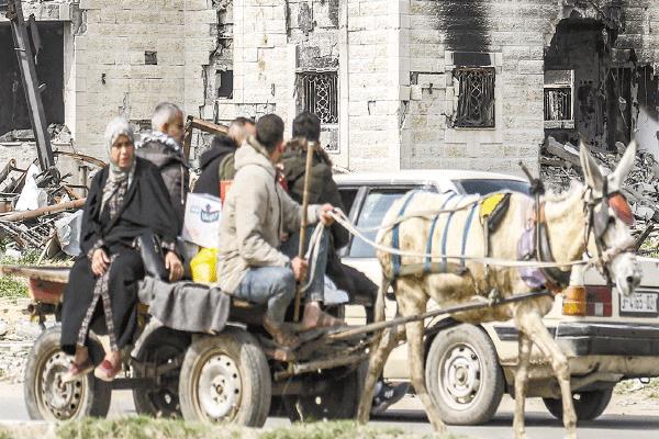 فلسطينيون يستقلون عربة كارو خلال مغادرتهم لمناطق مدمرة 