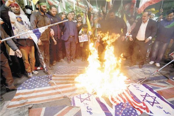 إيرانيون يحرقون الأعلام الإسرائيلية والأمريكية في ساحة فلسطين بطهران