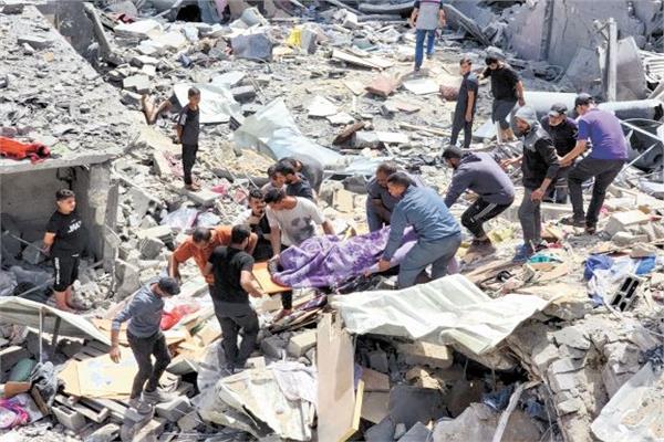 فلسطينيون ينتشلون جثمان أحد الشهداء من تحت الأنقاض