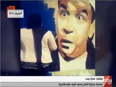 شاهد| فتاة ترسم جدارية للراحل محمد شرف بالإسكندرية