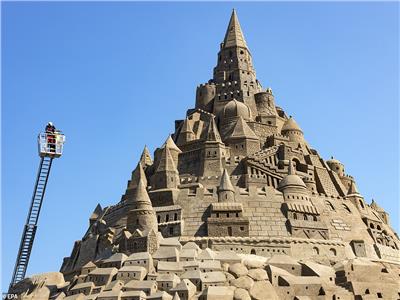 شاهد |20 فنانا يدخلون موسوعة «جينيس» بنحت أعلى قلعة رملية في العالم