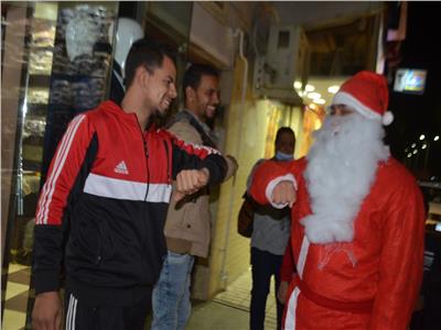 بعربة سندريلا.. بابا نويل يوزع كمامات على مواطنين في إسنا بالأقصر.. صور