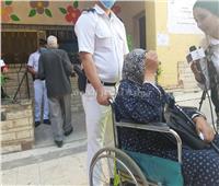 انتخابات النواب 2020| «الشرطة» تنقل مسنة بالكرسي المتحرك للإدلاء بصوتها