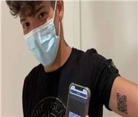 شاب يَشِم رمز تصريحه الصحي «QR» على ذراعه