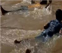 «شر البلية ما يضحك».. أطفال هنود يسبحون ويلعبون في مياه الأمطار| فيديو