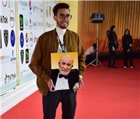 صور| حفيد أحمد خليل يحمل صورة جده على السجادة الحمراء لفيلم «رجل بلا وطن»