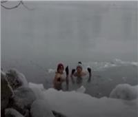 في درجة حرارة 20 تحت الصفر.. كنديان يسبحان في بحيرة متجمدة
