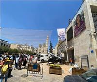 تعليق صور لشيرين أبو عاقلة قبالة كنيسة المهد قبيل زيارة بايدن لها