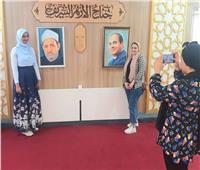 رواد معرض الإسكندرية للكتاب يلتقطون صورا تذكارية مع صورتي الرئيس وشيخ الأزهر
