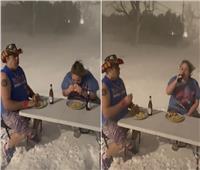 تحد غريب.. أمريكيان يتناولان برجر وبطاطا مقلية وسط العاصفة الثلجية!
