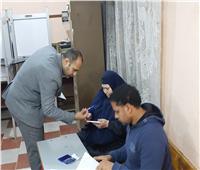 رئيس لجنة انتخابية بشبرا الخيمة يقدم المساعدة لسيدة عجوز للإدلاء بصوتها