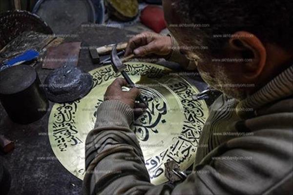 الحاج بيومي يواصل رسم لوحاته الفنية على النحاس