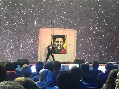 رسام أجنبي يرسم صورة لـ«محمد صلاح» على مسرح شباب العالم