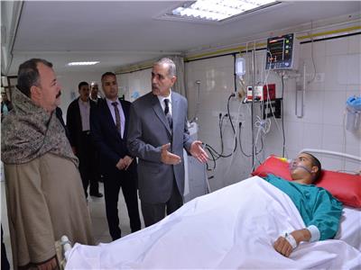 محافظ أسيوط اللواء جمال نور الدين مع أحد المصابين