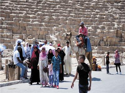 مواطنون يركبون الجمال فى ساحة الأهرامات