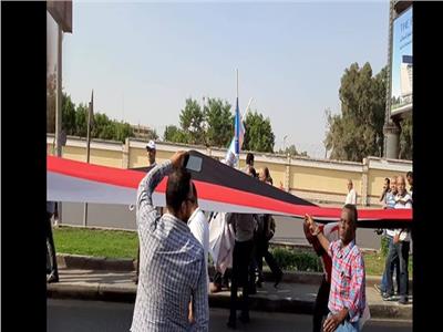 مواطنون يحملون أطول علم في مصر في مسيرة ضخمة بطريق النصر
