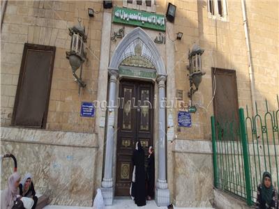 الأم وابنتها على باب مسجد الحسين المغلق