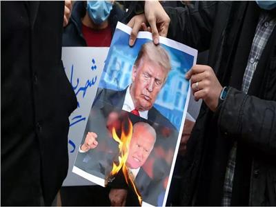 طلاب في طهران يحرقون صورا للرئيس الأمريكي دونالد ترامب وجو بايدن احتجاجا على اغتيال فخري زاده