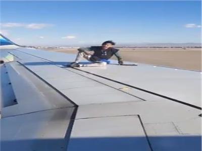 أمريكي يصعد على جناح طائرة