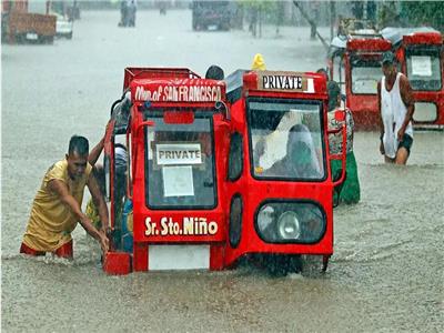 أشخاص يجرون عربة في شارع غرق جرّاء الأمطار الغزيرة في مينداناو في الفليبين