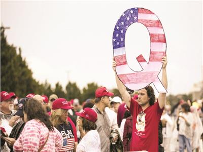 أحد اتباع «كيو أنون» يرفع رمز الجماعة «Q»