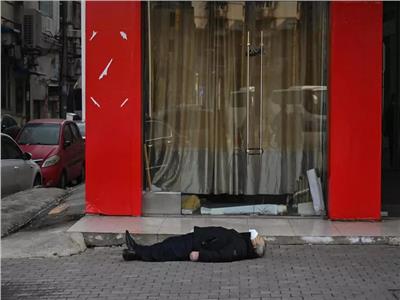 رجل ميت مستلق على رصيف في مدينة ووهان الصينية ف