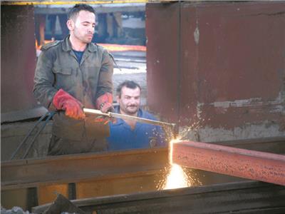 عمال مصنع الحديد والصلب يعملون على زيادة الإنتاج
