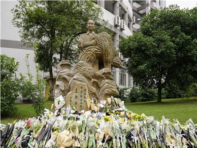 الأساتذة والطلاب يضعون زهورا أمام تمثال يوان لونغ بينغ بجامعة الجنوب الغربي في 22 مايو