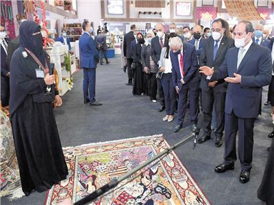 الرئيس عبدالفتاح السيسى خلال حديثه مع إحدى العارضات فى معرض «تراثنا»