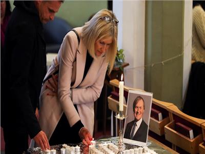 اسرة ديفيد أميس تضئ الشموع اثناء جنازته