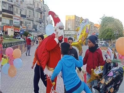 حتفالًا بالكريسماس.. بابا نويل يوزع الهدايا على المارة في شوارع قنا