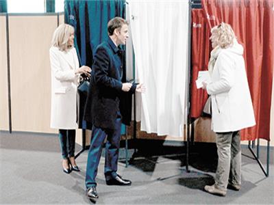 ماكرون وزوجته أثناء الإدلاء بأصواتهم فى الدورة الأولي للانتخابات  