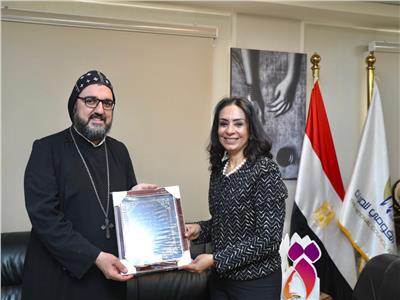  الدكتورة مايا مرسي خلال لقاءها بكاهن الكنيسة