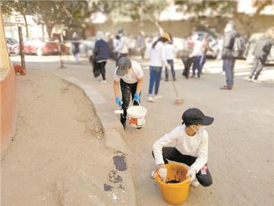 ■ طلاب مدرسة الشهيد عماد أثناء نشاط تنظيف الشوارع