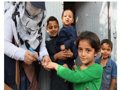 فتاة صغيرة تتلقى التلقيح ضد شلل الأطفال من العاملات الصحيات في كابول ، أفغانستان