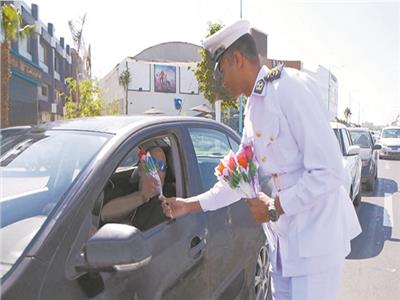 ضابط شرطة يوزع الورود على أحد المواطنين