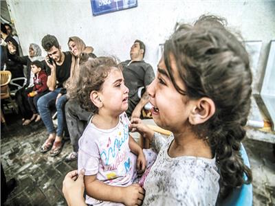 أطفال يبكون من الخوف وهم ينتظرون الرعاية الطبية فى غزة