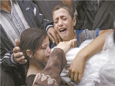 أطفال يبكون خلال وداع أحد أقاربهم بعد استشهاده فى غزة