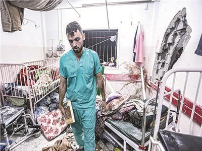 فلسطينى يتفقد حجم الدمار فى إحدى غرف مستشفى ناصر بعد قصفه
