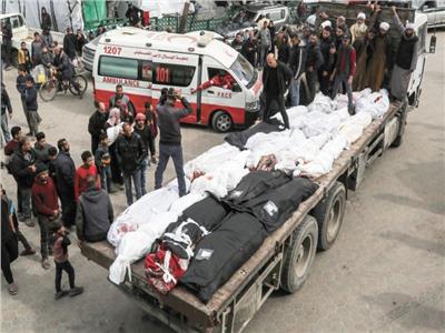 فلسطينيون ينقلون جثثا خلال جنازة جماعية فى مستشفى الأقصى فى غزة
