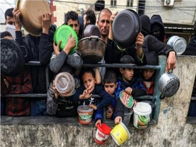 فلسطينيون بينهم أطفال ينتظرون الحصول على طعام