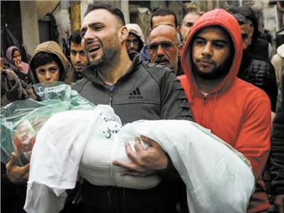 فلسطيني يحمل جثمان ابنه الرضيع ضحية القصف الإسرائيلي