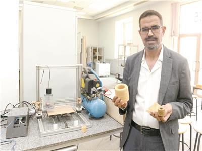  د. أحمد عبد العزيز يحمل أحد منتجات الماكينة