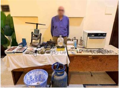 المتهم وأمامه المضبوطات