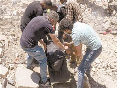 الأهالى ينتشلون جثة من تحت الأنقاض بلبنان